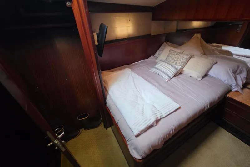 Slide: The Image of Cozy bedroom in 1987 Hatteras 52 Convertible yacht with plush bedding and wood paneling. - 23