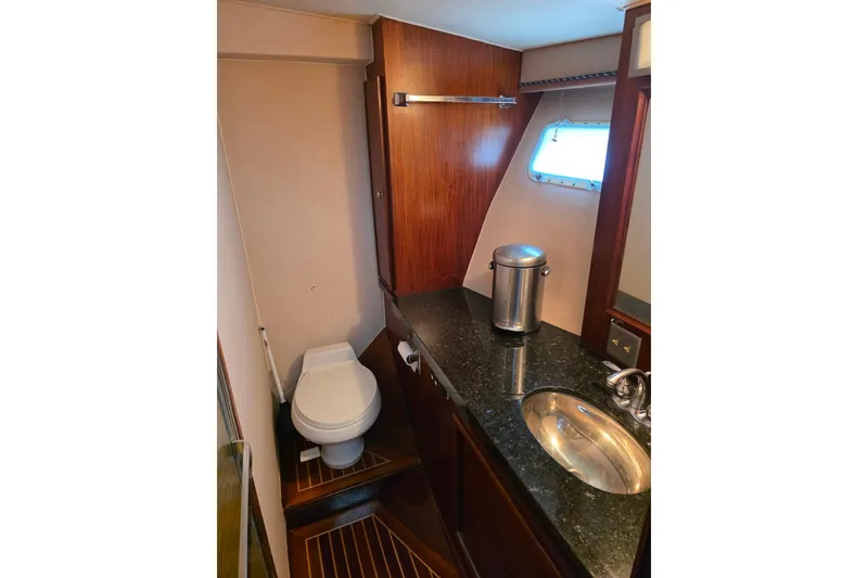 Slide: The Image of 1987 Hatteras 52 Convertible yacht bathroom with wood accents and modern fixtures. - 25