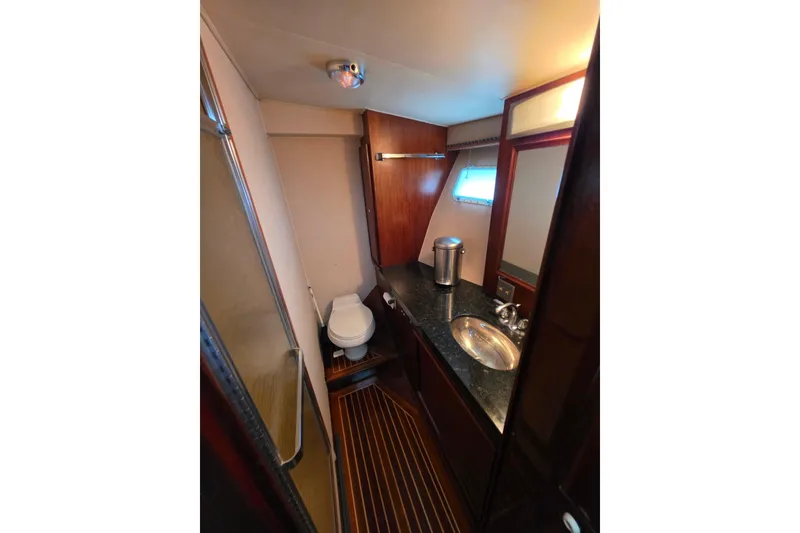 Slide: The Image of Bathroom interior of 1987 Hatteras 52 Convertible yacht with wood accents and modern fixtures. - 26