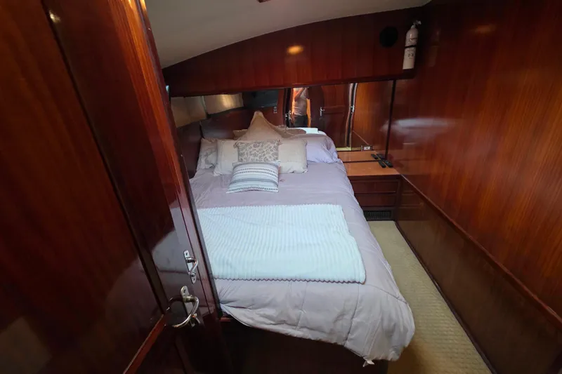 Slide: The Image of Luxurious bedroom interior of 1987 Hatteras 52 Convertible yacht with wood paneling. - 29