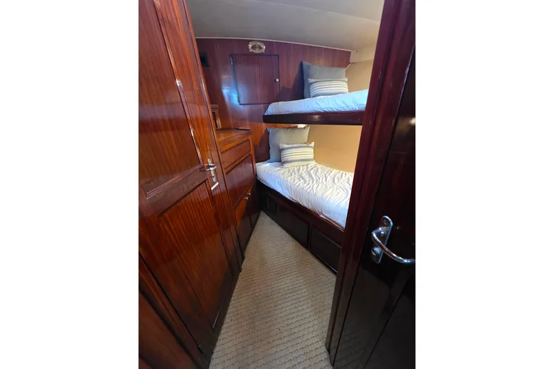 Slide: The Image of Cozy cabin with bunk beds in 1987 Hatteras 52 Convertible yacht, featuring polished wood interior. - 31