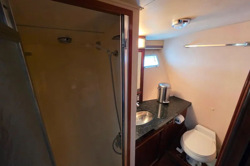 Slide: The Image of 1987 Hatteras 52 Convertible yacht bathroom with shower, sink, and toilet. - 36