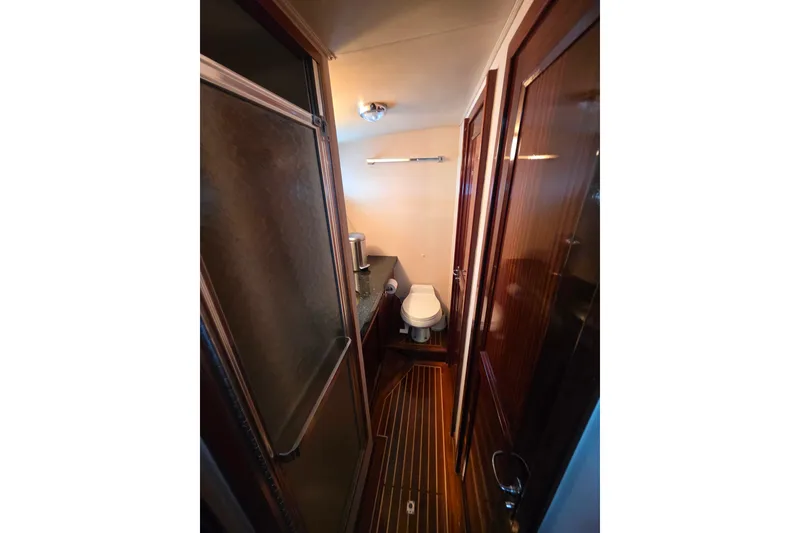 Slide: The Image of Bathroom interior of 1987 Hatteras 52 Convertible yacht with shower and wooden accents. - 37