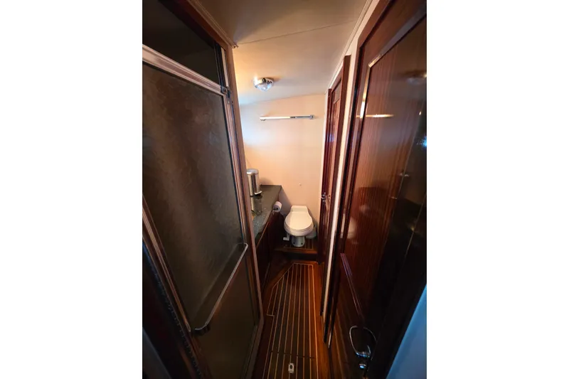 Slide: The Image of 1987 Hatteras 52 Convertible yacht bathroom with wood accents and compact design. - 38
