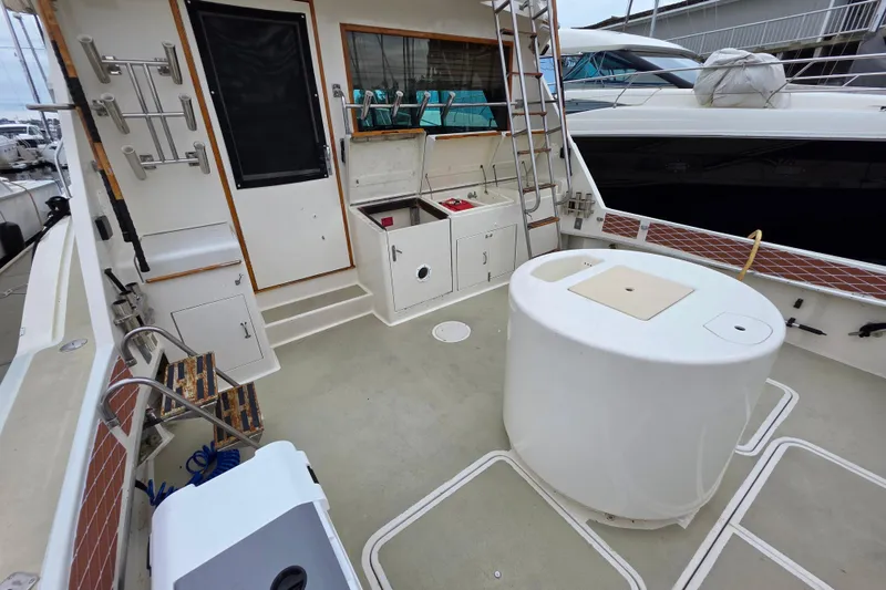 Slide: The Image of 1987 Hatteras 52 Convertible yacht deck with fishing rod holders and storage compartments. - 44