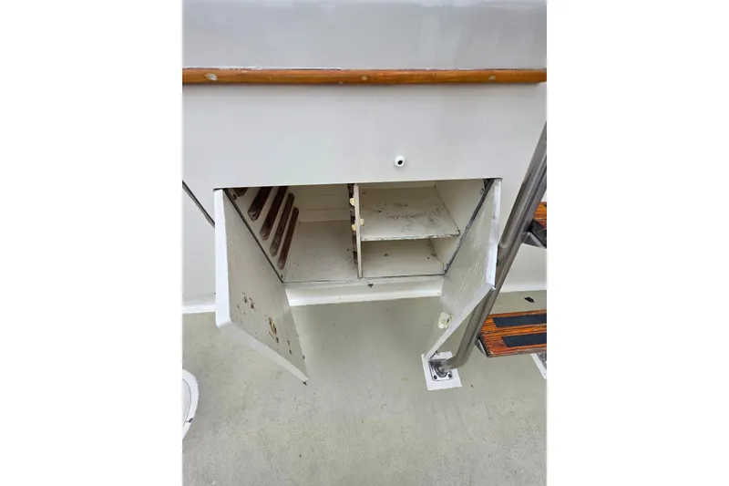 Slide: The Image of Open storage compartment on 1987 Hatteras 52 Convertible boat, showing shelves and wooden railing. - 45