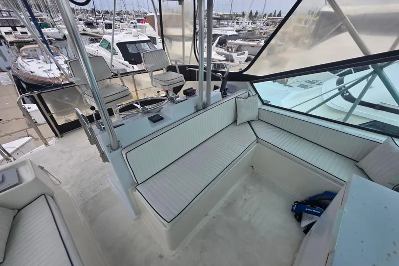 Slide: The Image of 1987 Hatteras 52 Convertible yacht interior with seating, docked at marina. - 51