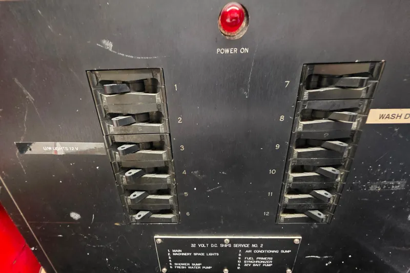 Slide: The Image of Electrical panel of a 1987 Hatteras 52 Convertible boat with switches and power indicator. - 82