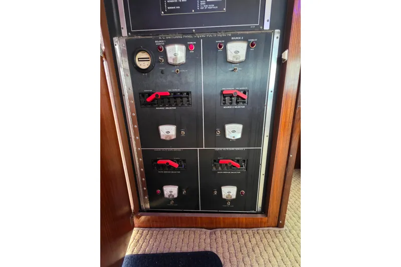 Slide: The Image of Electrical panel of a 1987 Hatteras 52 Convertible yacht, featuring switches and gauges. - 84