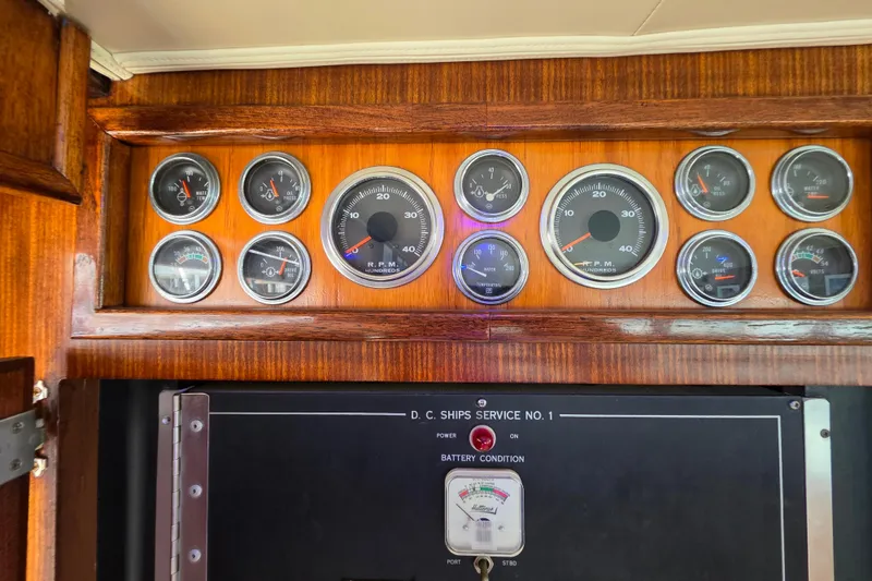 Slide: The Image of 1987 Hatteras 52 Convertible dashboard with gauges and battery condition panel. - 85