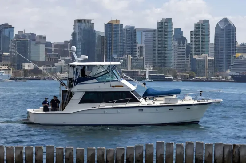 Slide: The Image of 1987 Hatteras 52 Convertible yacht cruising near city skyline. - 88