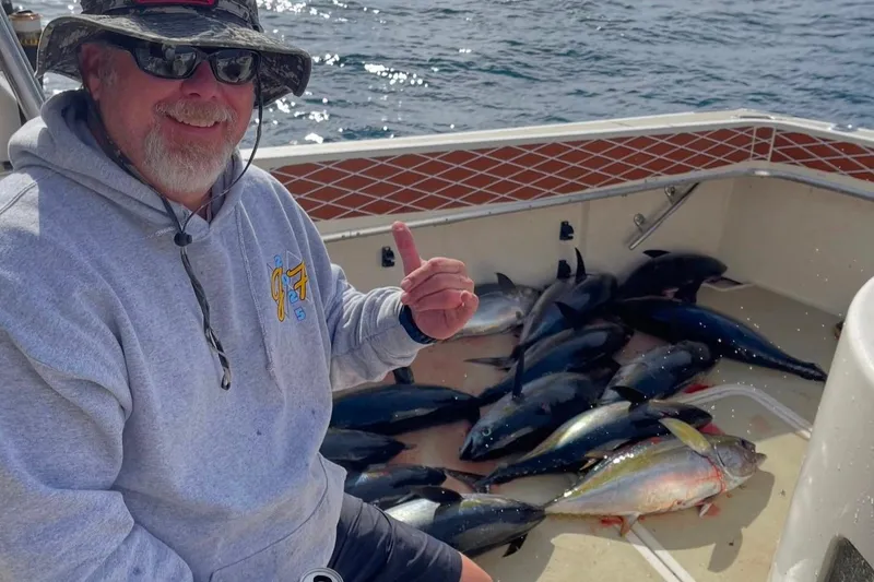 Slide: The Image of Man on 1987 Hatteras 52 Convertible with fresh tuna catch, smiling and pointing. - 91