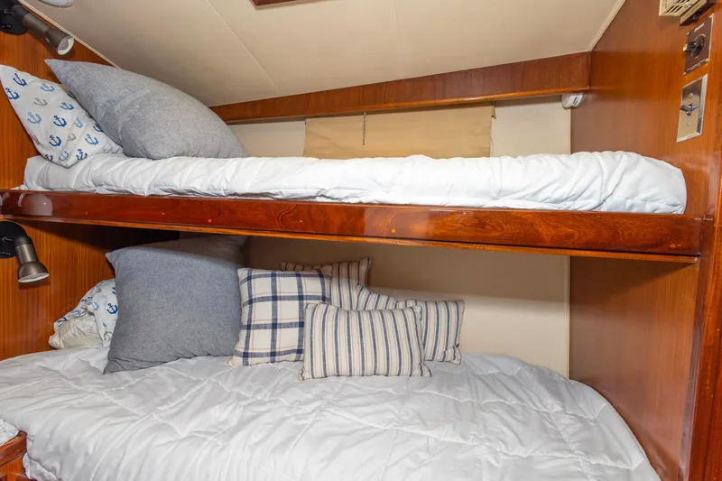 Slide: The Image of Bunk beds in 1987 Hatteras 52 Convertible yacht cabin with nautical-themed pillows. - 96