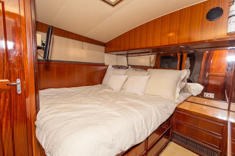 Slide: The Image of Luxurious cabin interior of 1987 Hatteras 52 Convertible yacht with wood paneling and cozy bedding. - 97