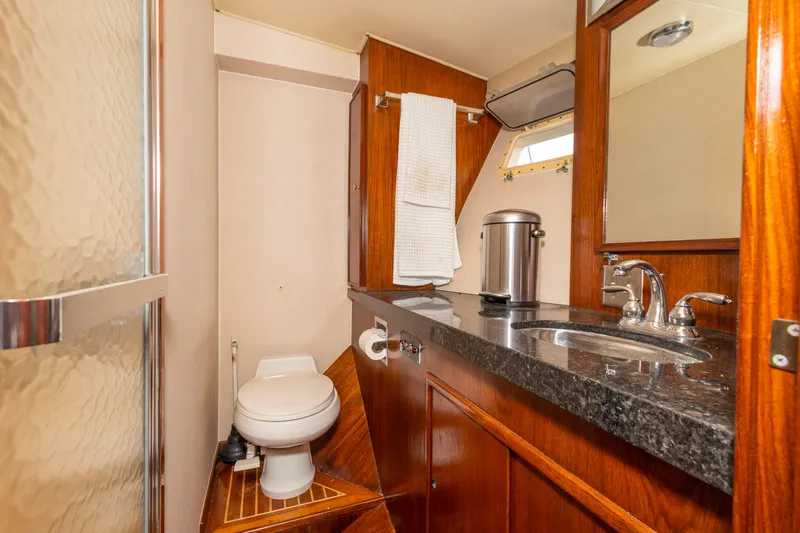 Slide: The Image of 1987 Hatteras 52 Convertible yacht bathroom with wood accents and modern fixtures. - 99