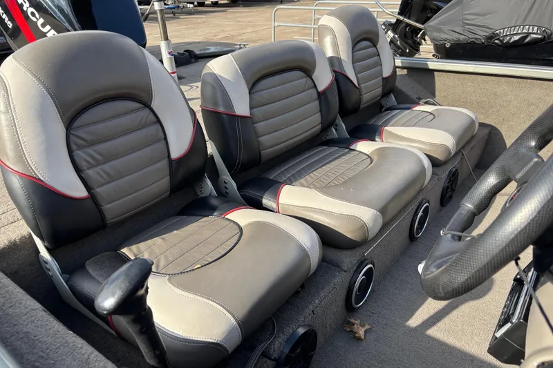 Slide: The Image of 2005 Bass Tracker V18 boat interior with three gray and black seats. - 2