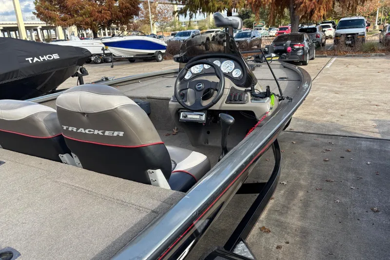 Slide: The Image of 2005 Bass Tracker V18 boat with dual seats and steering console in a parking area. - 4