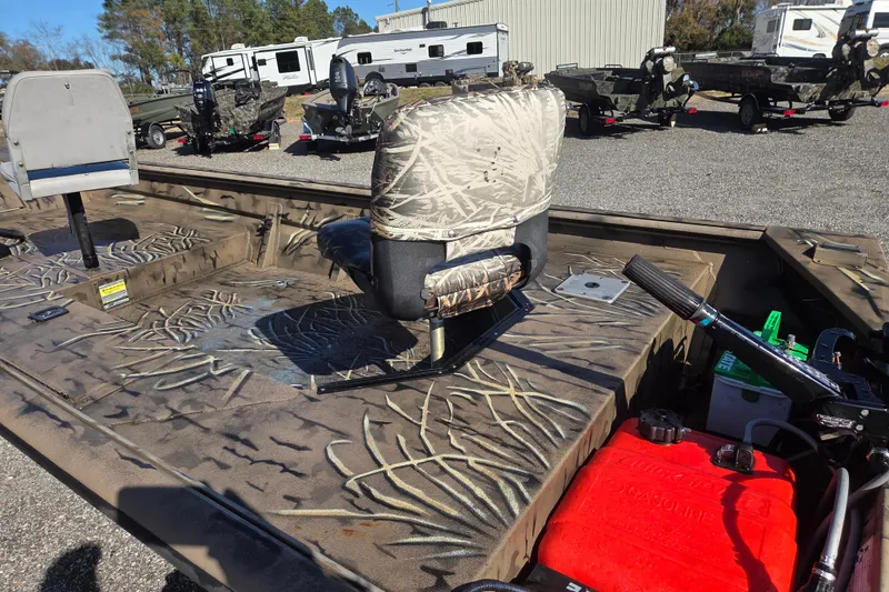 Slide: The Image of 2018 SeaArk DXS 1548 DKLD boat with camo seats and outboard motor, parked outdoors. - 13