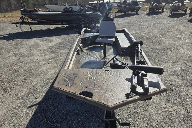 Slide: The Image of 2018 SeaArk DXS 1548 DKLD boat with camouflage design, parked on gravel lot. - 2