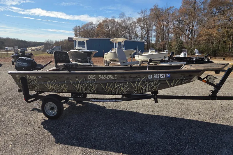 Slide: The Image of 2018 SeaArk DXS 1548 DKLD boat on trailer, camo design, parked outdoors. - 4