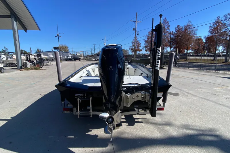 Slide: The Image of 2019 Crestliner 1800 Bay boat with outboard motor, parked outdoors on a sunny day. - 3