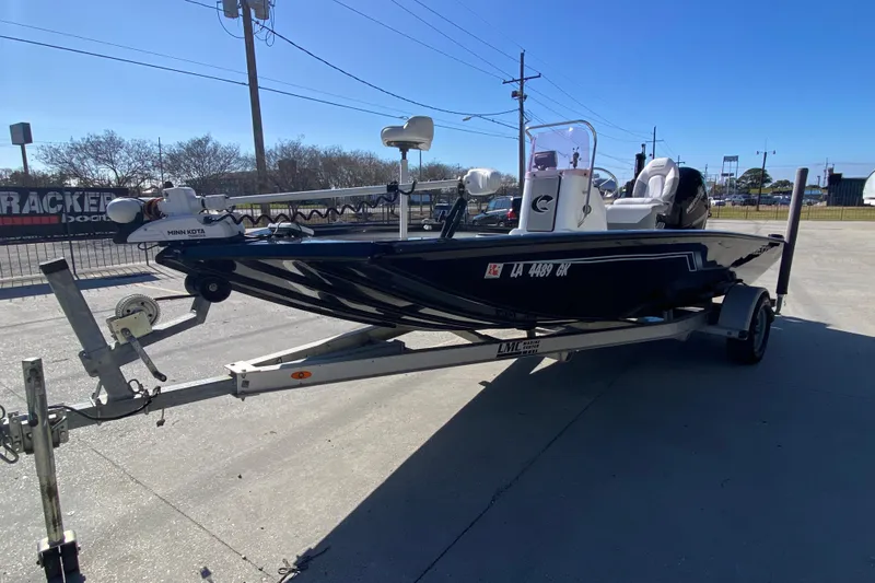 Slide: The Image of 2019 Crestliner 1800 Bay boat on trailer, parked outdoors under clear blue sky. - 6