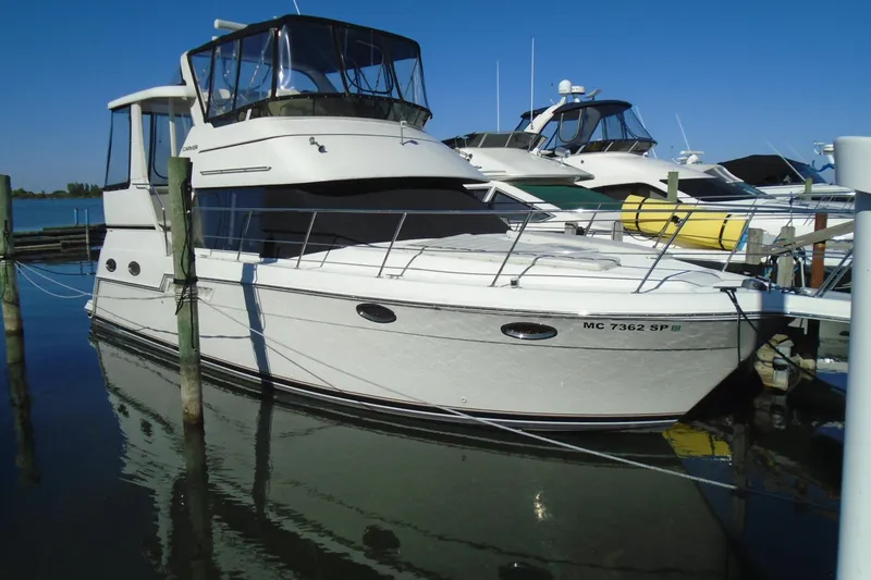 The Image of 2004 Carver 356 Motor Yacht docked at marina under clear blue sky. - 1