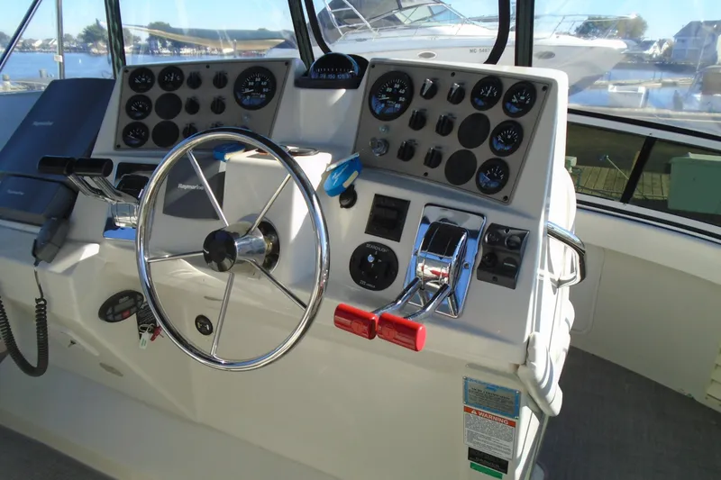 Slide: The Image of 2004 Carver 356 Motor Yacht helm with steering wheel and control panel. - 11