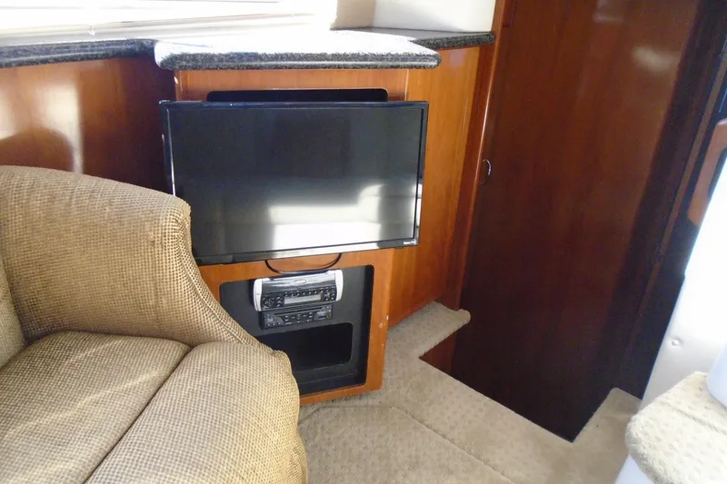 Slide: The Image of 2004 Carver 356 Motor Yacht interior with TV, stereo, and beige seating. - 38