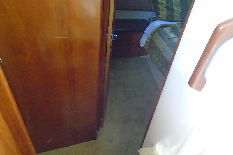 Slide: The Image of Interior view of 2004 Carver 356 Motor Yacht cabin with wooden door and bed. - 39