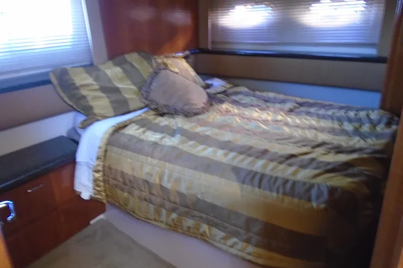 Slide: The Image of Cozy bedroom interior of 2004 Carver 356 Motor Yacht with striped bedding and soft lighting. - 40