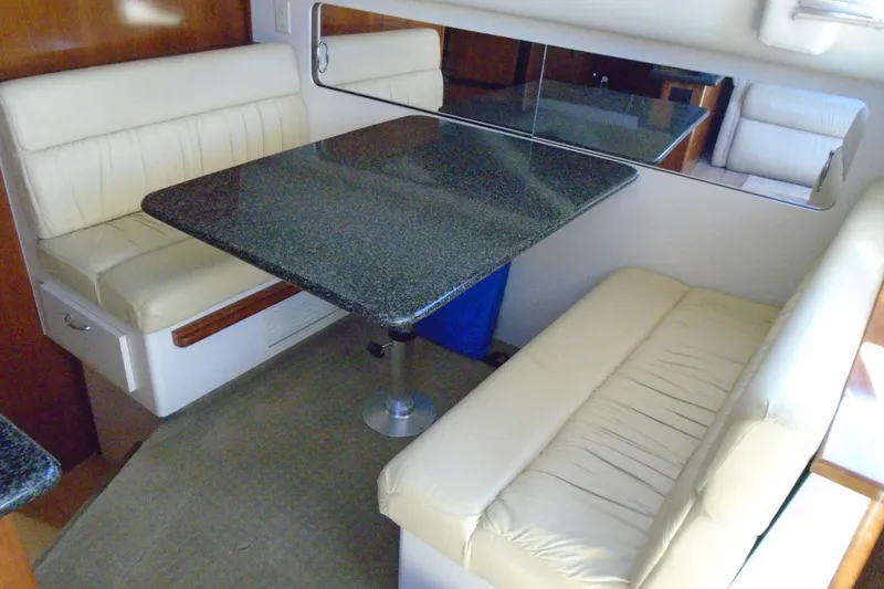 Slide: The Image of 2004 Carver 356 Motor Yacht interior with cushioned seating and granite-style table. - 24
