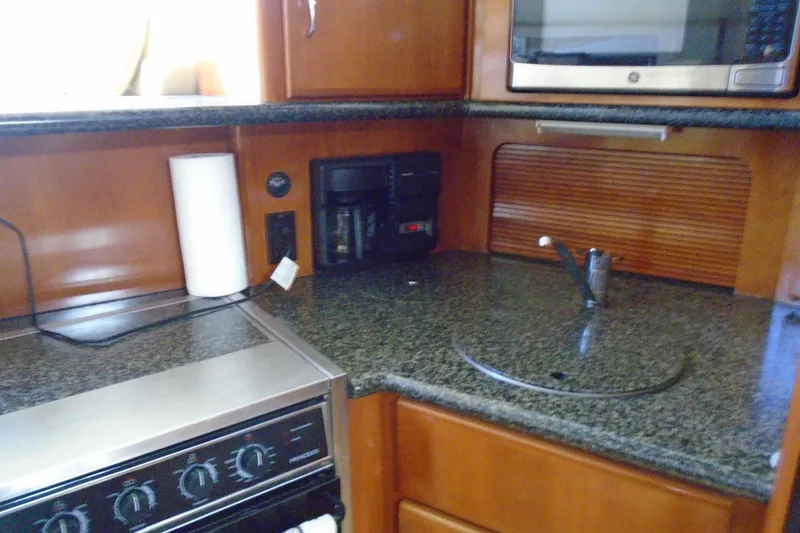 Slide: The Image of 2004 Carver 356 Motor Yacht kitchen with stove, sink, and microwave. - 26