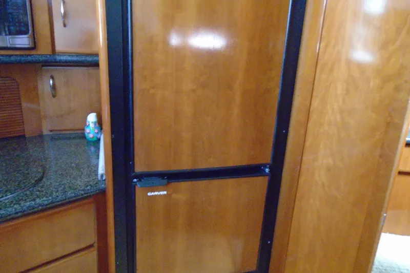 Slide: The Image of Interior of 2004 Carver 356 Motor Yacht with wooden cabinetry and built-in appliances. - 27