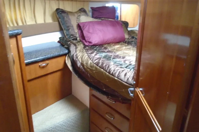 Slide: The Image of Cozy bedroom interior of 2004 Carver 356 Motor Yacht with wood cabinetry and plush bedding. - 33