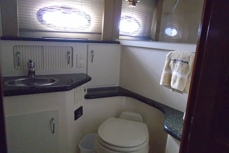 Slide: The Image of 2004 Carver 356 Motor Yacht bathroom with sink, toilet, and branded towel. - 44