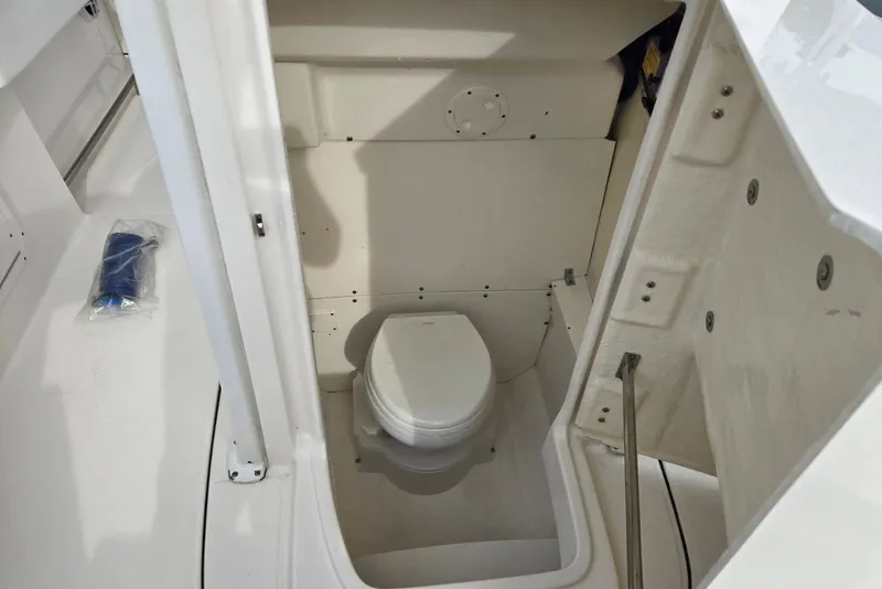 Slide: The Image of 2021 Robalo R242 Center Console boat interior with compact marine toilet. - 23