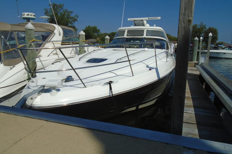 The Image of 2007 Sea Ray 40 Sundancer yacht docked at marina under clear blue sky. - 0