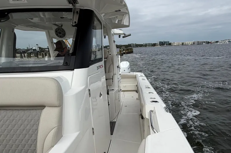 Slide: The Image of 2026 Solace 37 CS boat cruising on a calm waterway near a cityscape. - 12