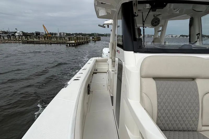 Slide: The Image of 2026 Solace 37 CS boat cruising near a dock on a cloudy day. - 13