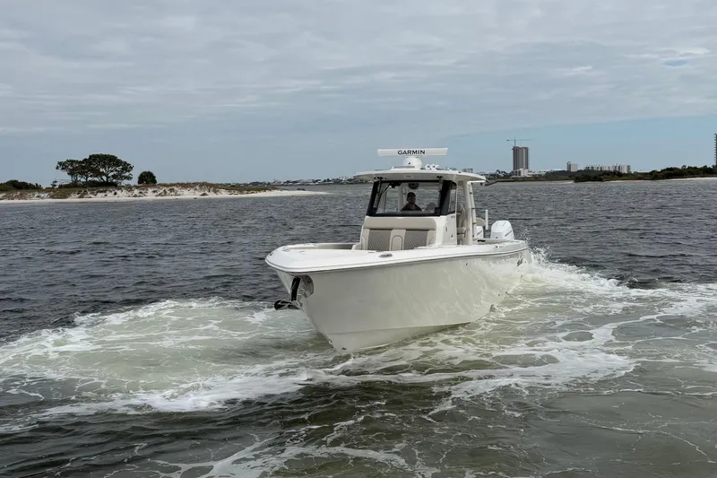 Slide: The Image of 2026 Solace 37 CS boat cruising on open water near a sandy shoreline. - 5