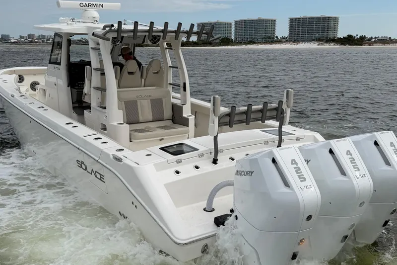 Slide: The Image of 2026 Solace 37 CS boat with triple Mercury 425 engines cruising near shoreline. - 8