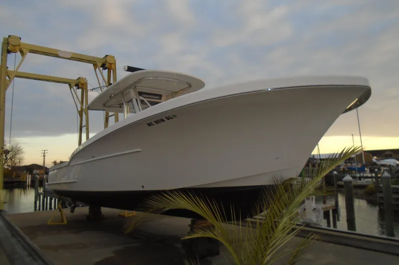 Slide: The Image of 2006 Buddy Davis 34 Center Console boat on lift at marina during sunset. - 12