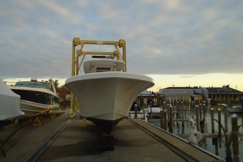 Slide: The Image of 2006 Buddy Davis 34 Center Console boat on lift at marina, under cloudy sky. - 13