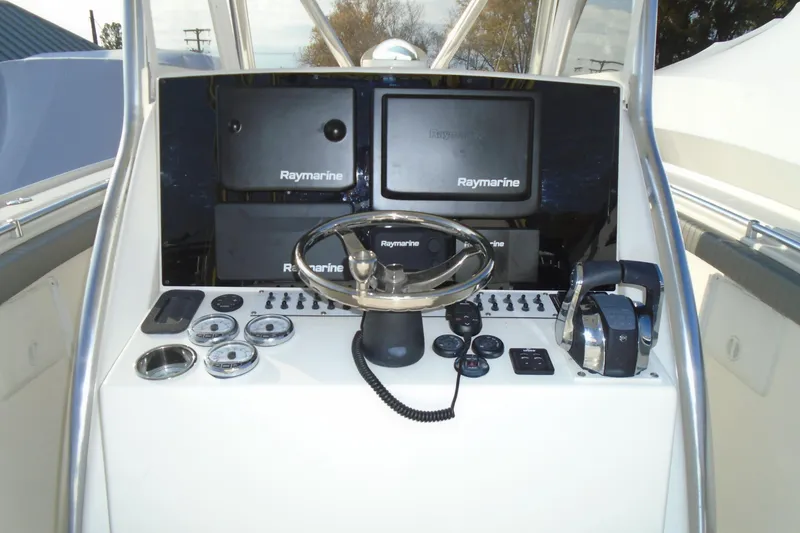 Slide: The Image of 2006 Buddy Davis 34 Center Console helm with Raymarine electronics and steering wheel. - 26
