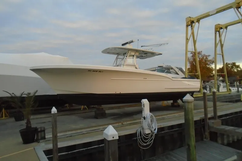 Slide: The Image of 2006 Buddy Davis 34 Center Console boat docked at marina under cloudy sky. - 8