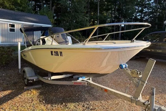 Slide: The Image of 2021 Boston Whaler 130 Super Sport boat on trailer in driveway. - 2