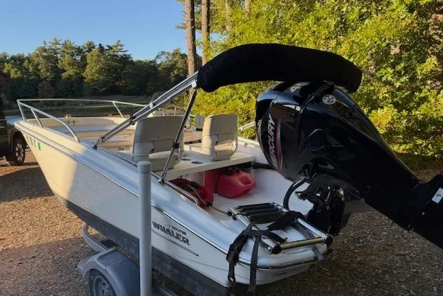 Slide: The Image of 2021 Boston Whaler 130 Super Sport boat on trailer, surrounded by trees. - 3