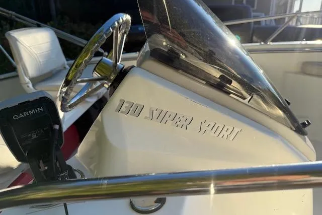Slide: The Image of 2021 Boston Whaler 130 Super Sport boat interior with steering wheel and Garmin device. - 5