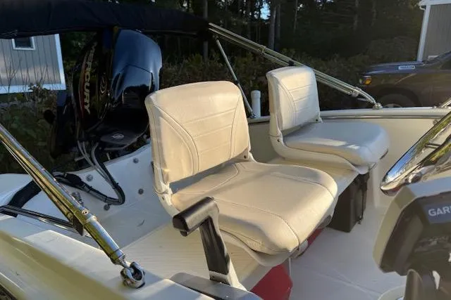 Slide: The Image of 2021 Boston Whaler 130 Super Sport boat interior with seating and Mercury engine. - 6